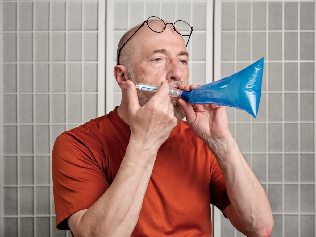 Senior man performing breath test to diagnose SIBO